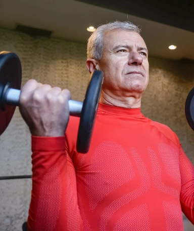 Older man lifting weights personal training