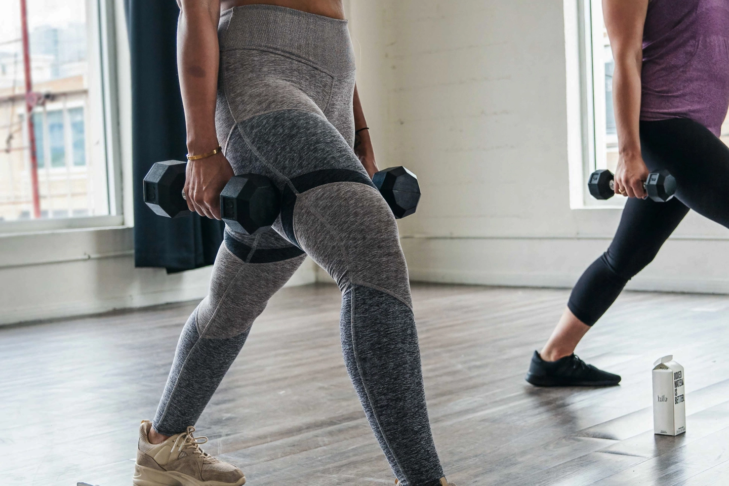 a person in workout pants holding ten pound weights