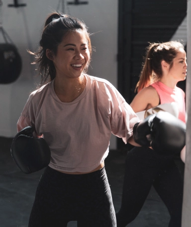 two women with boxing gloves on smiling
