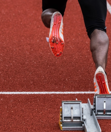 Man on a track field running personal training